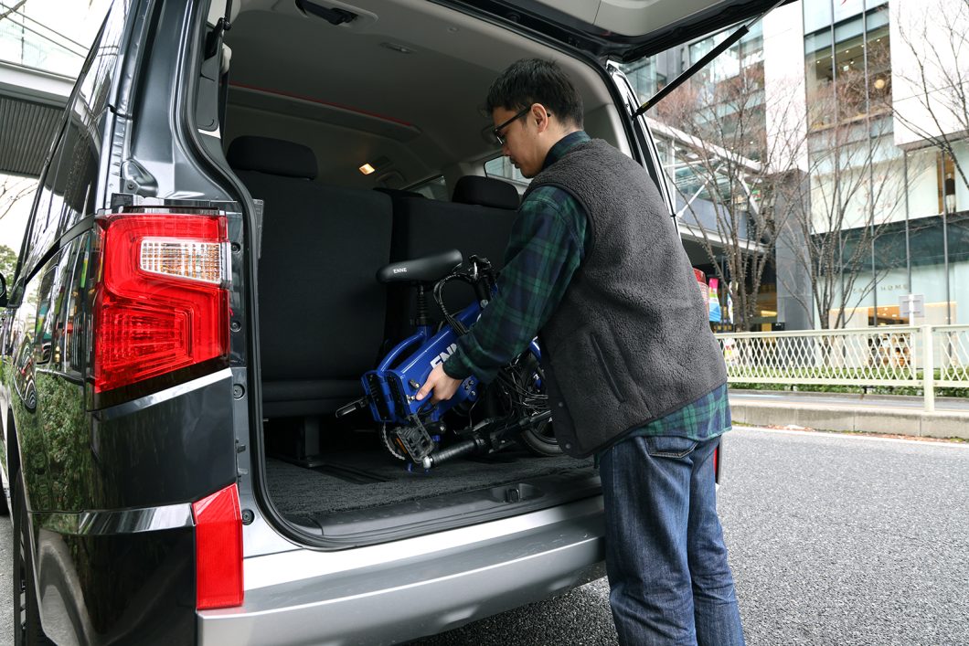 特定小型のENNEを折りたたんで自動車に乗せる様子